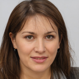 Joyful white adult female with long  brown hair and brown eyes