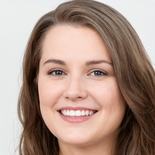 Joyful white young-adult female with long  brown hair and green eyes