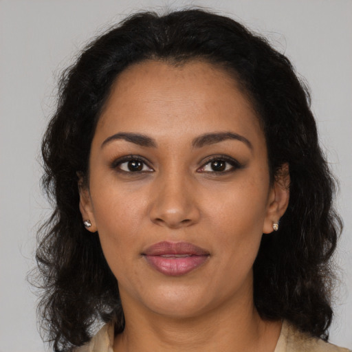 Joyful latino adult female with medium  brown hair and brown eyes