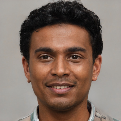 Joyful latino young-adult male with short  black hair and brown eyes