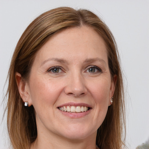 Joyful white adult female with long  brown hair and green eyes