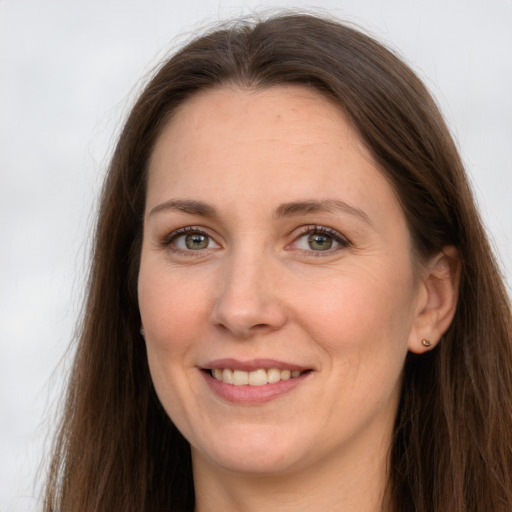 Joyful white adult female with long  brown hair and grey eyes