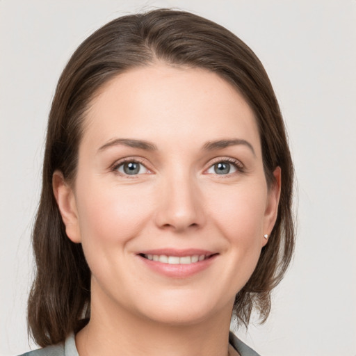 Joyful white young-adult female with medium  brown hair and grey eyes