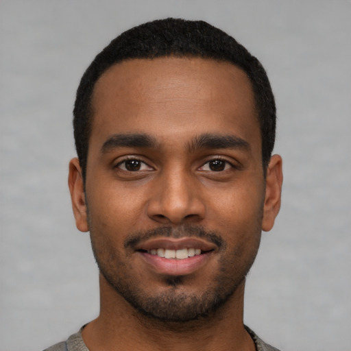 Joyful black young-adult male with short  black hair and brown eyes