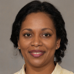 Joyful black adult female with medium  brown hair and brown eyes