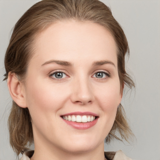 Joyful white young-adult female with medium  brown hair and grey eyes