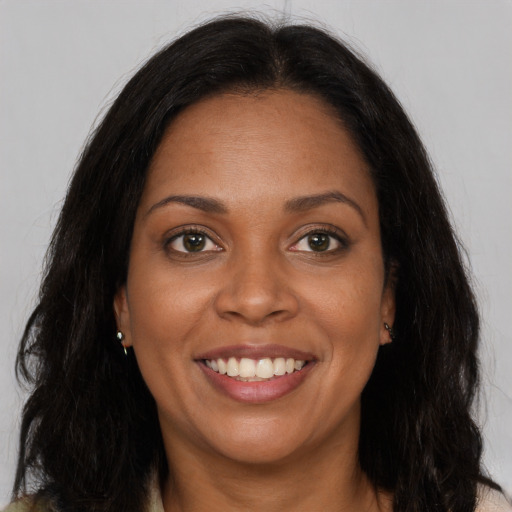 Joyful black young-adult female with long  brown hair and brown eyes