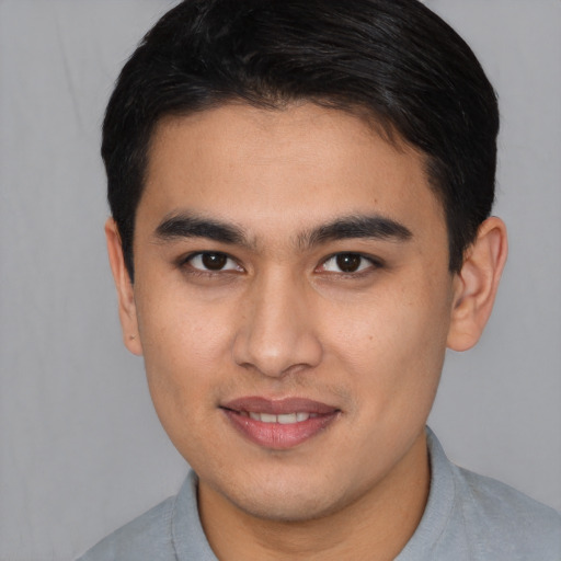 Joyful latino young-adult male with short  brown hair and brown eyes