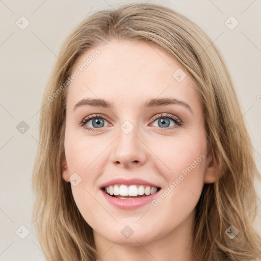 Joyful white young-adult female with long  brown hair and blue eyes