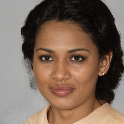 Joyful black young-adult female with medium  black hair and brown eyes