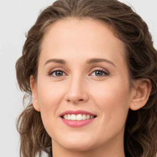 Joyful white young-adult female with long  brown hair and green eyes