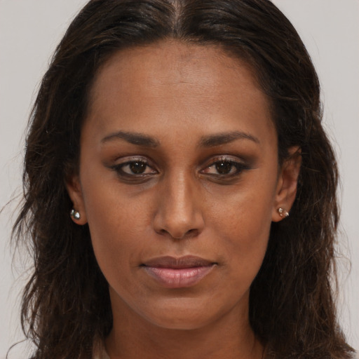 Joyful black young-adult female with long  brown hair and brown eyes
