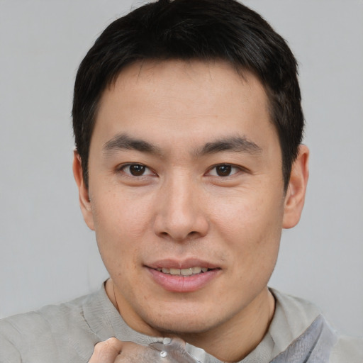 Joyful asian young-adult male with short  brown hair and brown eyes
