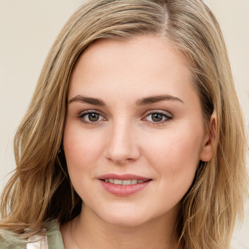 Joyful white young-adult female with long  brown hair and green eyes