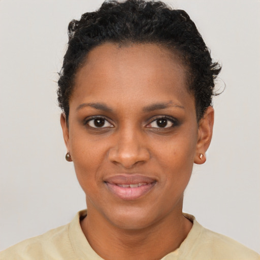 Joyful black young-adult female with short  black hair and brown eyes
