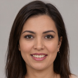 Joyful white young-adult female with long  brown hair and brown eyes