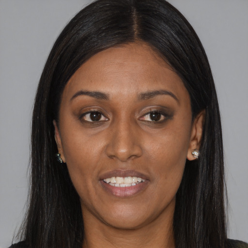 Joyful black young-adult female with long  brown hair and brown eyes