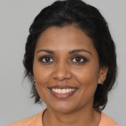 Joyful black adult female with medium  brown hair and brown eyes