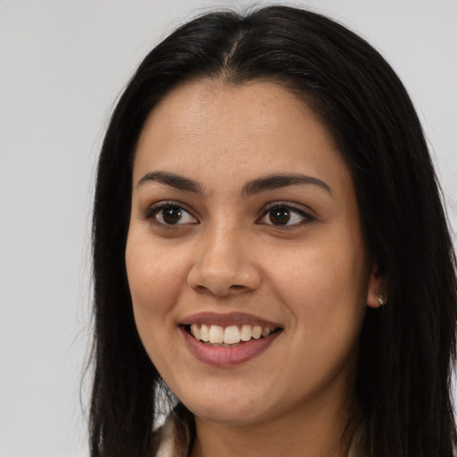 Joyful latino young-adult female with long  brown hair and brown eyes
