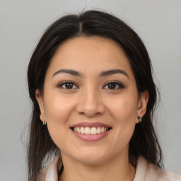 Joyful latino young-adult female with long  brown hair and brown eyes