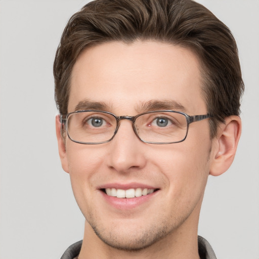 Joyful white young-adult male with short  brown hair and grey eyes