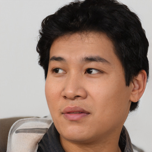 Joyful asian young-adult male with short  black hair and brown eyes