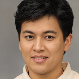 Joyful latino young-adult male with short  brown hair and brown eyes