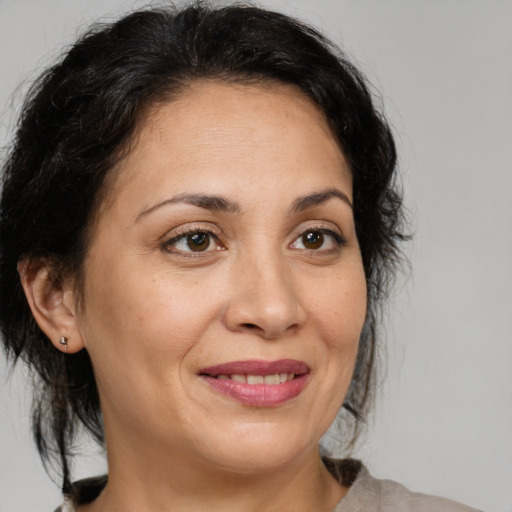 Joyful latino adult female with medium  brown hair and brown eyes