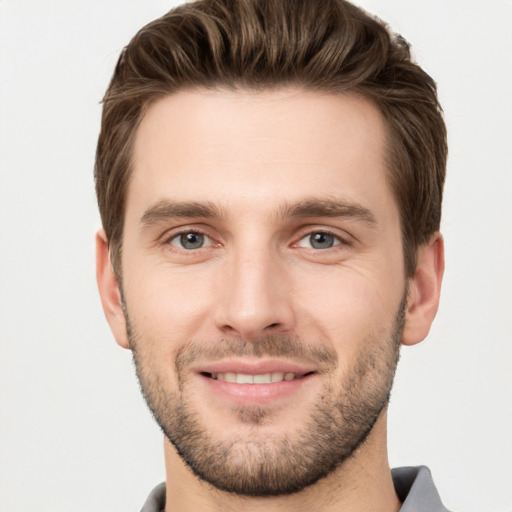 Joyful white young-adult male with short  brown hair and grey eyes