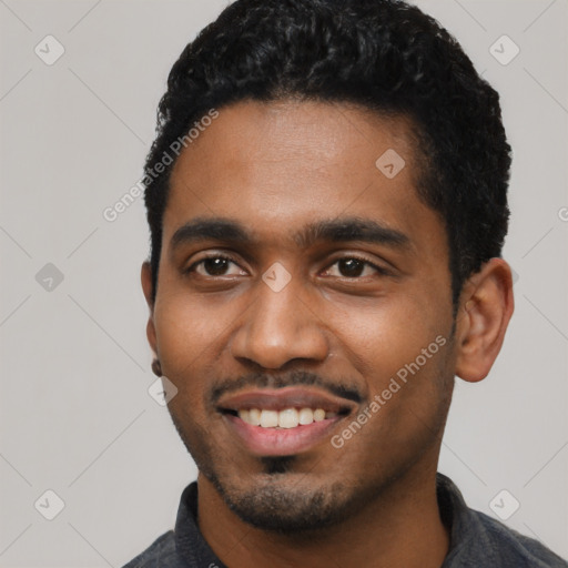 Joyful black young-adult male with short  black hair and brown eyes