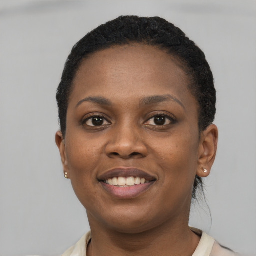 Joyful black young-adult female with short  black hair and brown eyes