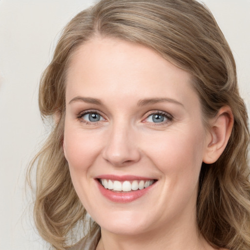 Joyful white young-adult female with long  brown hair and blue eyes