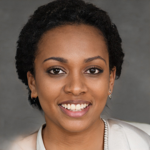 Joyful black young-adult female with short  black hair and brown eyes