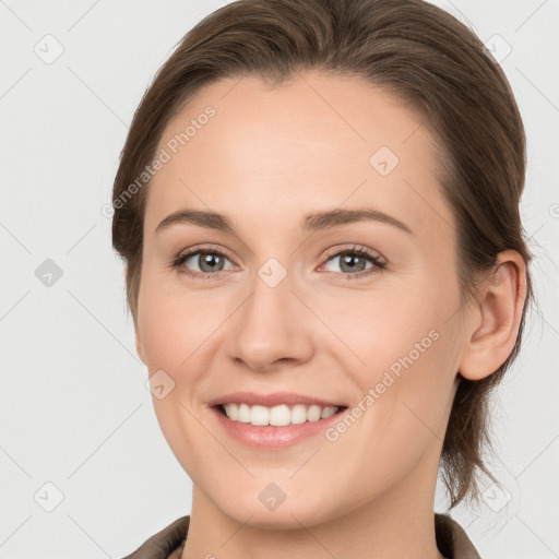 Joyful white young-adult female with medium  brown hair and grey eyes