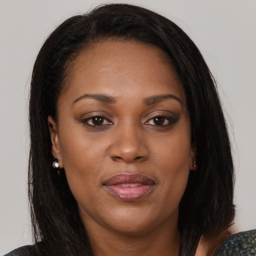 Joyful black adult female with medium  brown hair and brown eyes