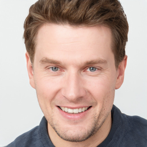 Joyful white adult male with short  brown hair and grey eyes