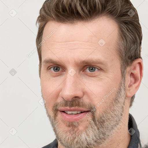 Joyful white adult male with short  brown hair and grey eyes