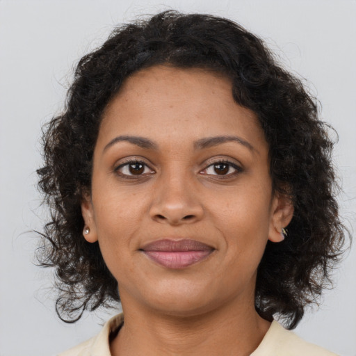 Joyful black young-adult female with medium  brown hair and brown eyes