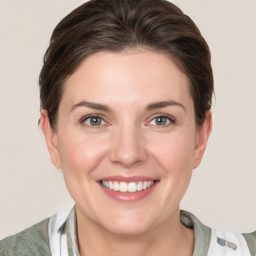 Joyful white young-adult female with short  brown hair and grey eyes