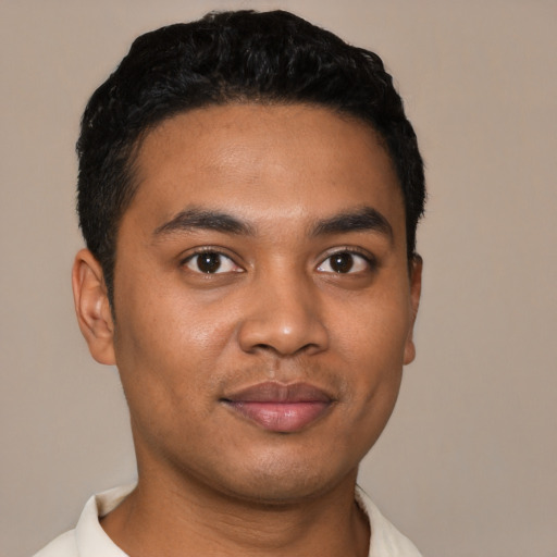 Joyful latino young-adult male with short  black hair and brown eyes