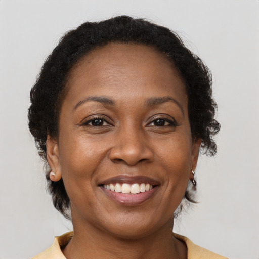 Joyful black adult female with medium  brown hair and brown eyes