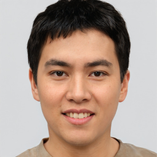 Joyful asian young-adult male with short  brown hair and brown eyes