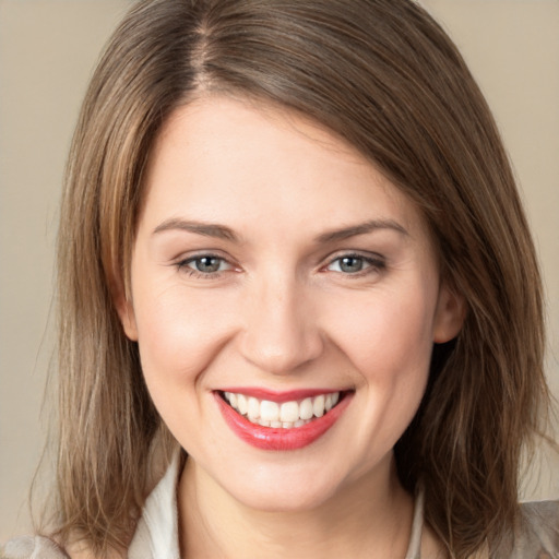 Joyful white young-adult female with medium  brown hair and grey eyes