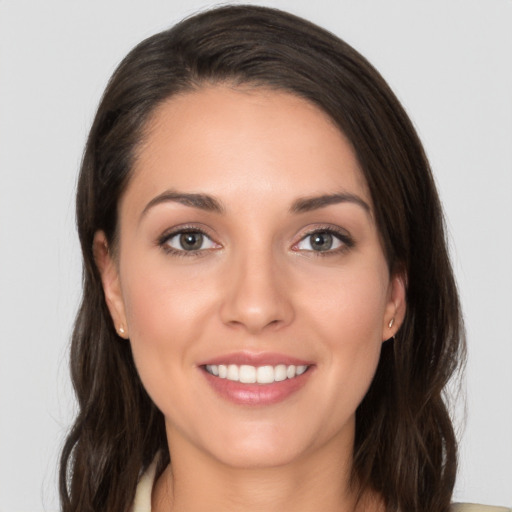 Joyful white young-adult female with long  brown hair and brown eyes