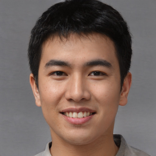 Joyful asian young-adult male with short  brown hair and brown eyes