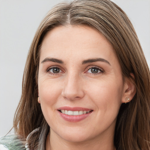 Joyful white young-adult female with long  brown hair and green eyes