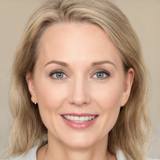 Joyful white adult female with medium  brown hair and blue eyes