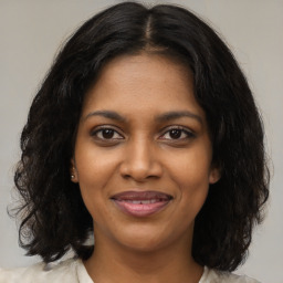 Joyful black young-adult female with medium  brown hair and brown eyes