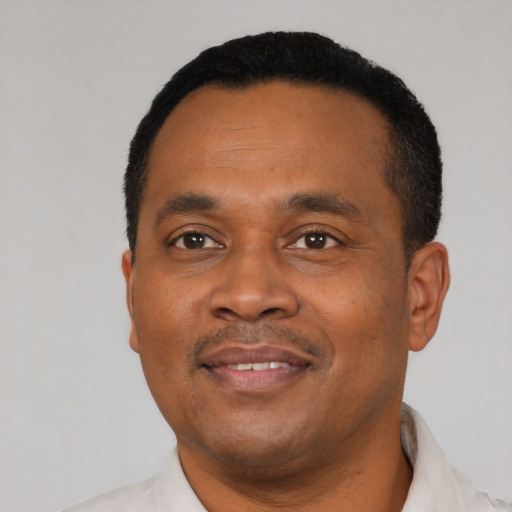 Joyful black young-adult male with short  black hair and brown eyes