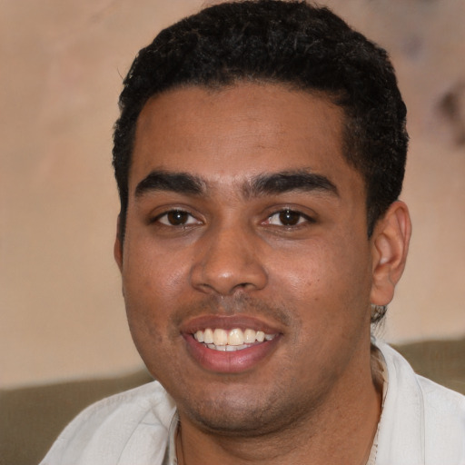 Joyful black young-adult male with short  black hair and brown eyes